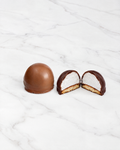 Twee artisanale melocakes van Elisabeth Chocolatier: een in melkchocolade en een in donkere chocolade, doorgesneden met de marshmallow en boterkoek zichtbaar
