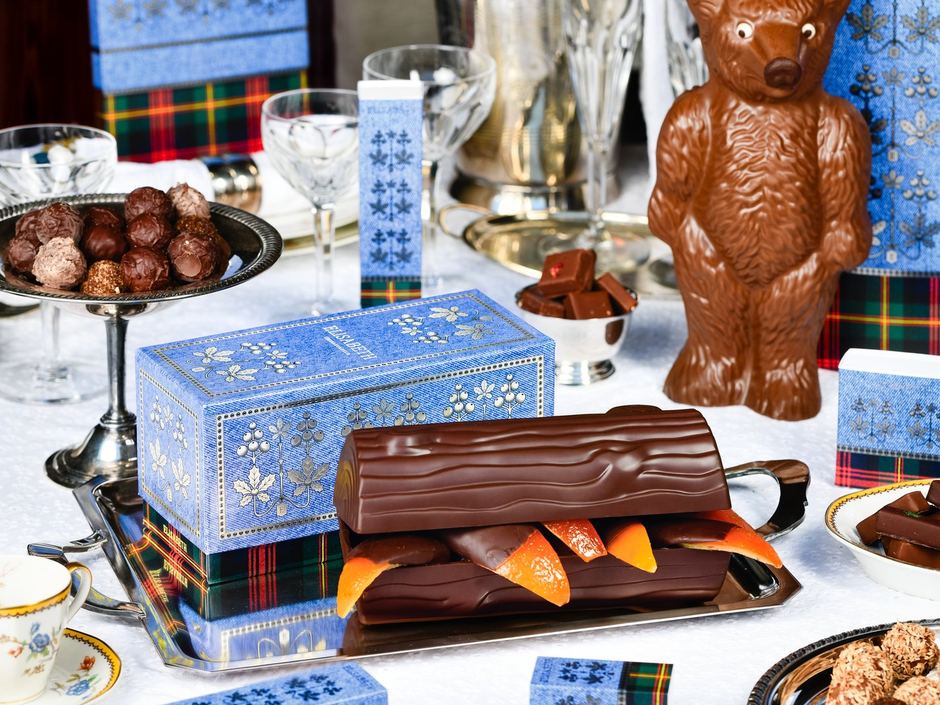 Eindejaarstafel met een chocoladebeer, een bûche en geschenkdozen