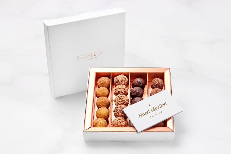 Open truffeldoos met een kaartje met een hotellogo, op marmer